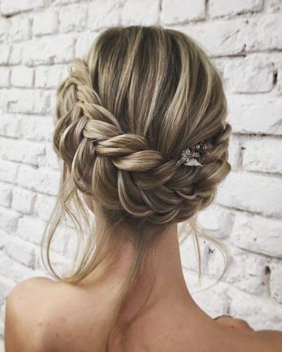 a chic twisted low bun with a small bump and some locks down for a timelessly romantic look