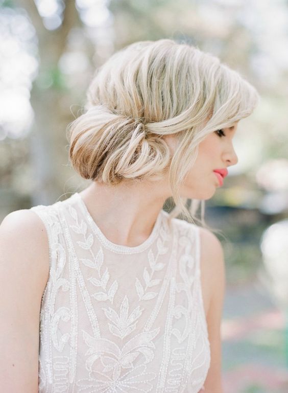 a low bun with a bump and an oversized gilded accessory is ideal for a minimalist bride