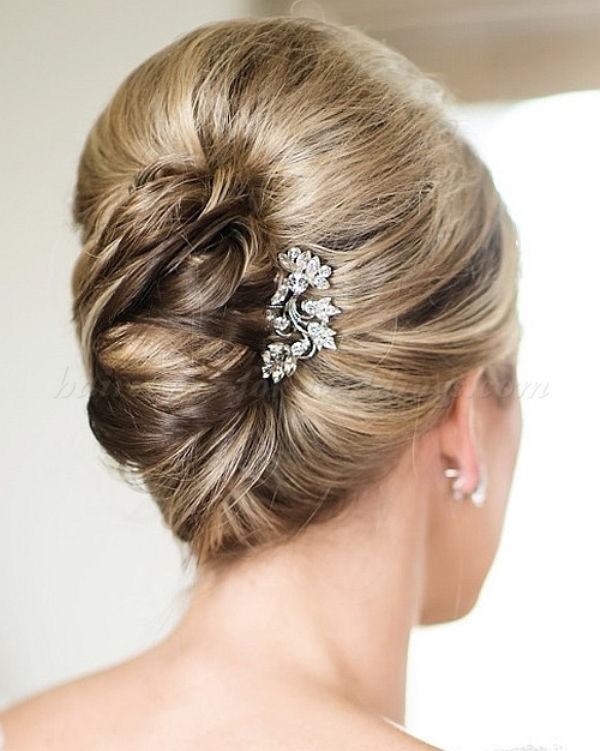 a low French twisted updo with a volume on top and locks down is a stylish idea for a effortlessly chic bride
