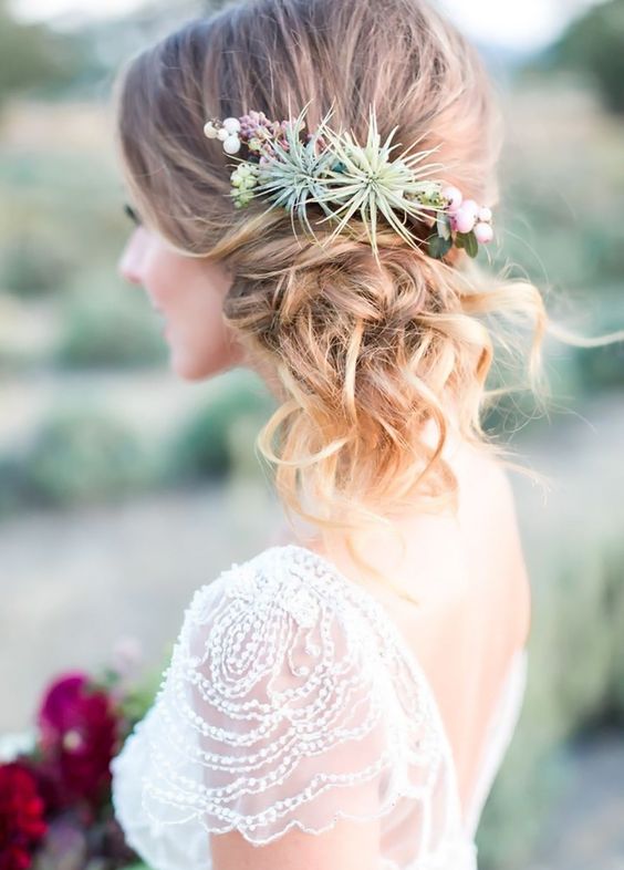 curled side swept hairstyle with a floral crown