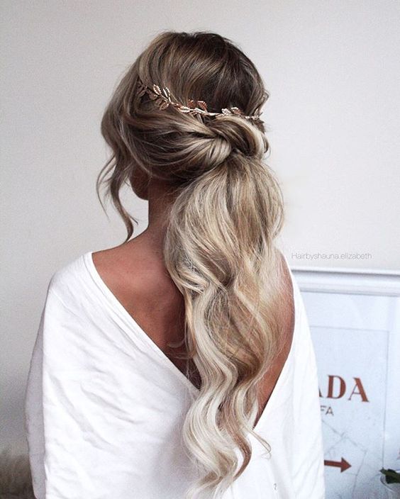 a low twisted ponytail with some wavy locks down and wavy ends is a chic and casual idea