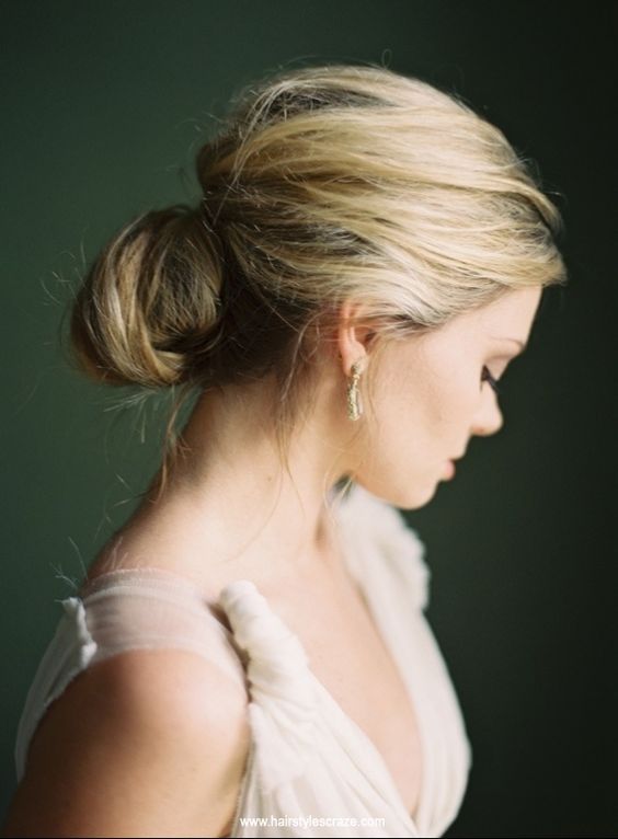 a low bun with a twist and a messy top for a refined and effortless look