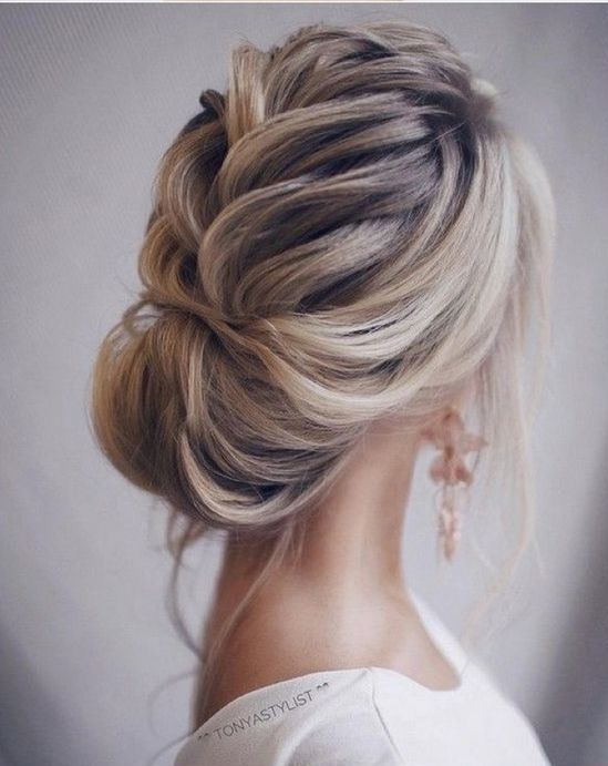 a low chignon hairstyle with a bit of mess, locks down and a rhinestone hairpiece