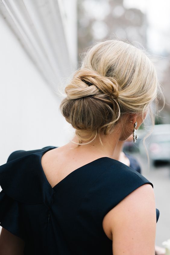 a low side swept twisted chignon with some bangs and a rhinestone hairpiece for an accent