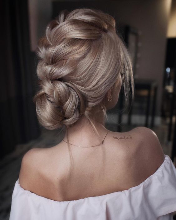 a lose fishtail braided updo with a halo is a chic and cool option for a romantic bride