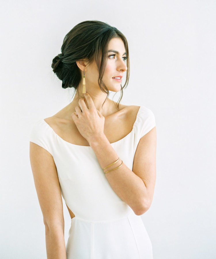 a minimalist and very refined low bun with a bump and a messy touch is amazing for a modern yet romantic bride
