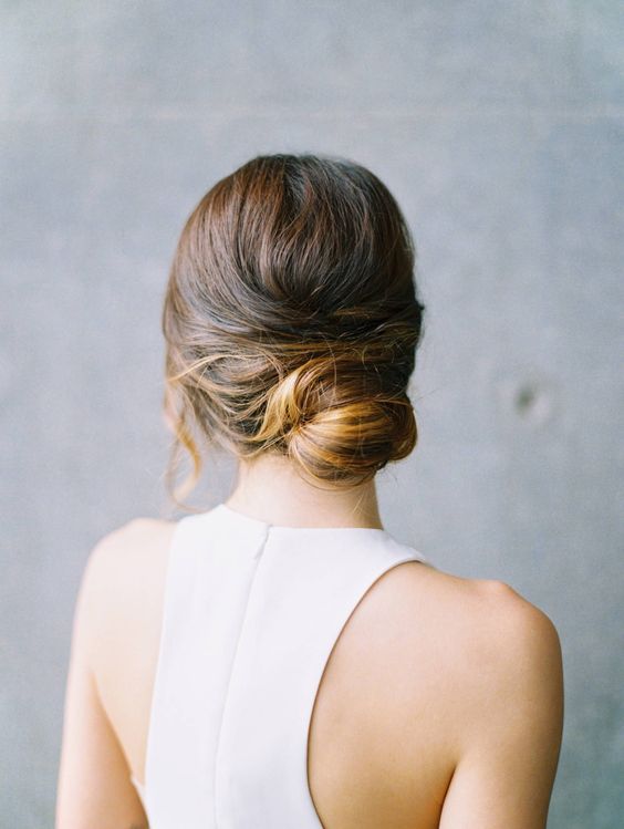 a simple low updo with waves is all you need for a simple and effortlessly chic bridal look, great for a modern bride