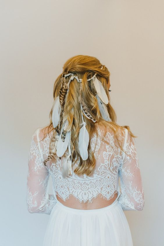 a folksy wedding hairstyle, a half updo with a braided halo, a fishtail and French braids hanging down and a floral crown