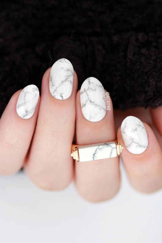 light pink matte nails and a white marble accent nail for a trendy feel in your look