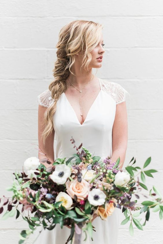 a messy braid is always a good idea for any bride because braids are in trend and they fit many styles