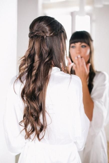 an elegant twisted and curly half updo accessorized with a shiny snowflake hairpiece