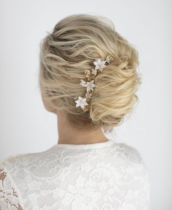 a messy wavy French twist updo with a messy top, a messy twisted chignon and locks down plus a rhinstone hairpiece