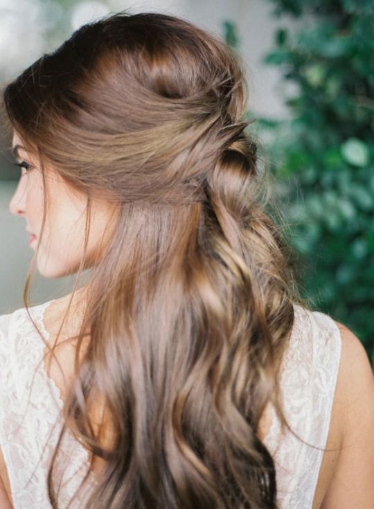 braided wavy half updo with a bold floral hairpiece to embrace the season