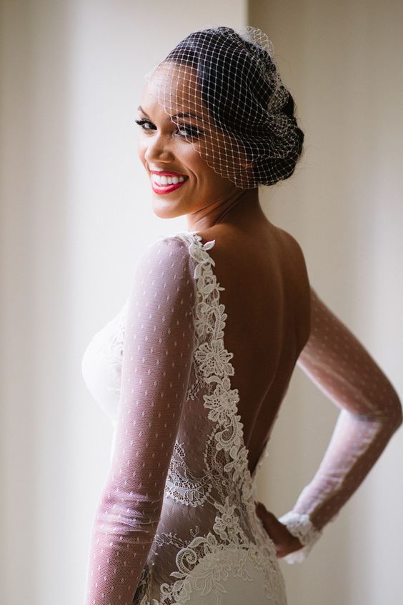 chic wavy updo with a bridal lace headpiece and a birdcage veil