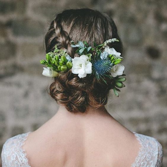 braided updo with bold and neutral flowers