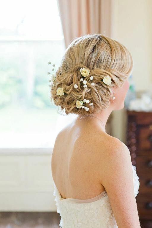 messy updo with small fresh blooms looks cute