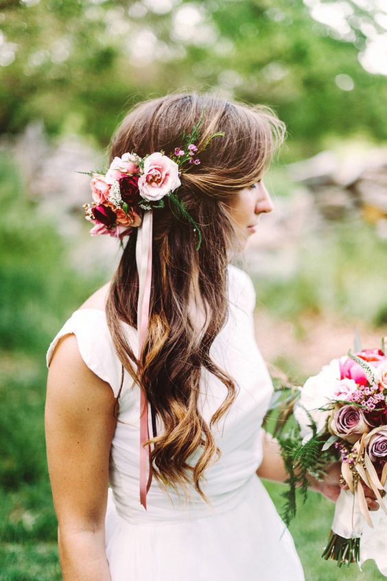 messy curly wedding half updo with tropical flowers