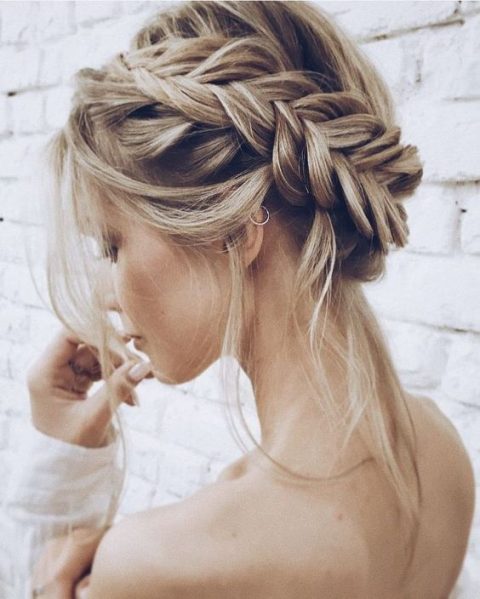 a messy and textural low bun with a bump and some locks down is a modern casual idea