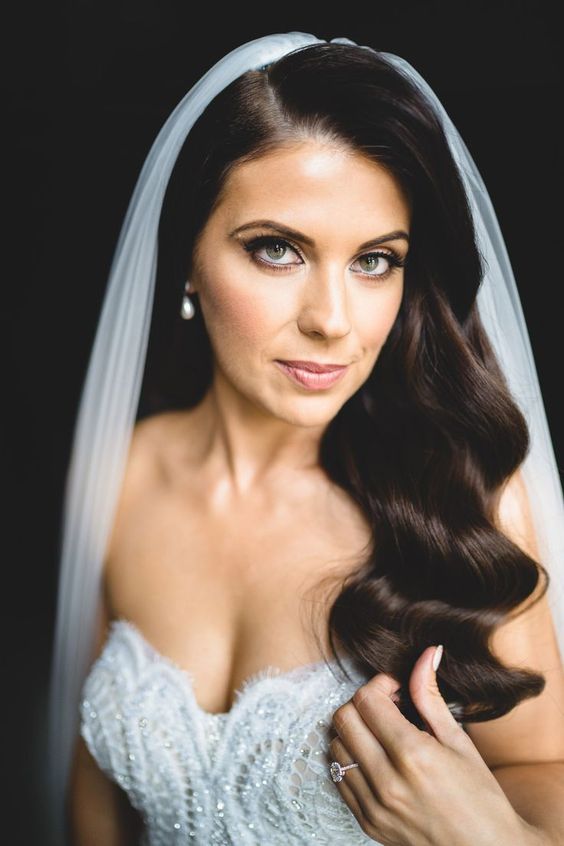 long vintage waves accented with a birdcage veil and a burgundy lip look very elegant and vintage-inspired