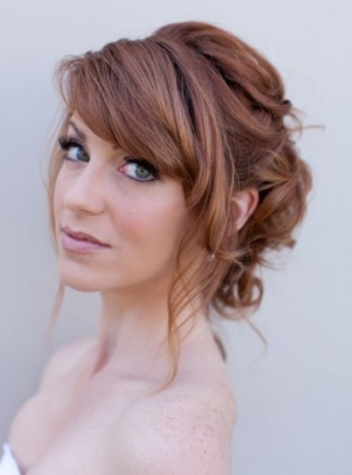 a top knot, much volume and bangs for an elegant and chic bridal look with a fully embellished dress