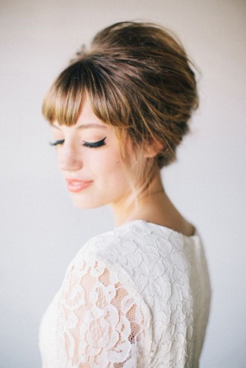 an elegant top knot with a braid on top and bangs is gorgeous and timeless option