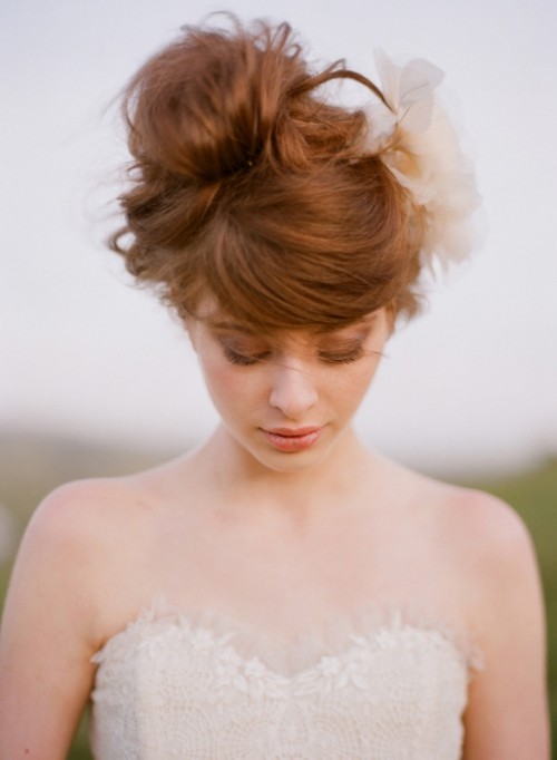 a very sleek updo with a short and curled bang for a minimalist bridal look