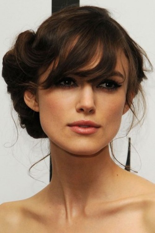 a long and wavy half updo with a bump and bangs is a classic hairstyle that fits many bridal styles