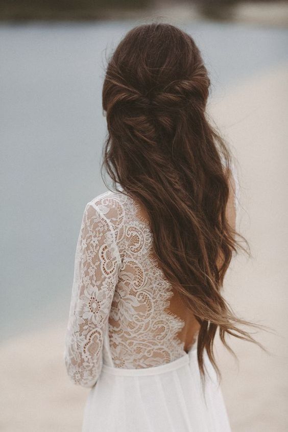 a beautiful boho wedding hairstyle with a fishtail braid on the front and waves down plus eucalyptus