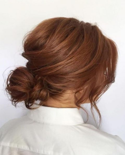 a romantic low side swept updo with curls and a bump is a chic idea for a bride with medium length hair