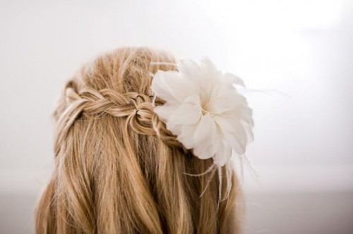 an updo that consists of several braids and is spruced up with fresh blooms