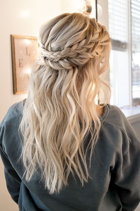 a wavy updo with a braided halo is a chic and timeless idea for a boho, rustic or just romantic bride